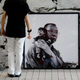 A visitor stands in front of a photograph of Nobel Laureate Liu Xiaobo carrying a puppet, taken by his wife Liu Xia, during her photo exhibition in Hong Kong June 9, 2012. Liu Xia has been under house arrest since her husband won the Nobel Peace Prize in 2010. REUTERS/Bobby Yip (CHINA - Tags: POLITICS SOCIETY CIVIL UNREST) - RTR33BNY